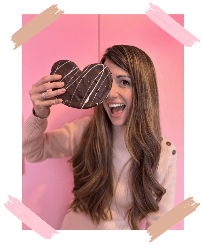 Isabel con una palmera de chocolate y kinder en la mano tapando su cara y sonriendo